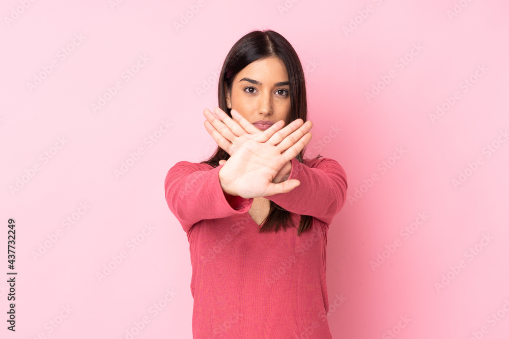 Young caucasian woman over isolated background making stop gesture with her hand to stop an act