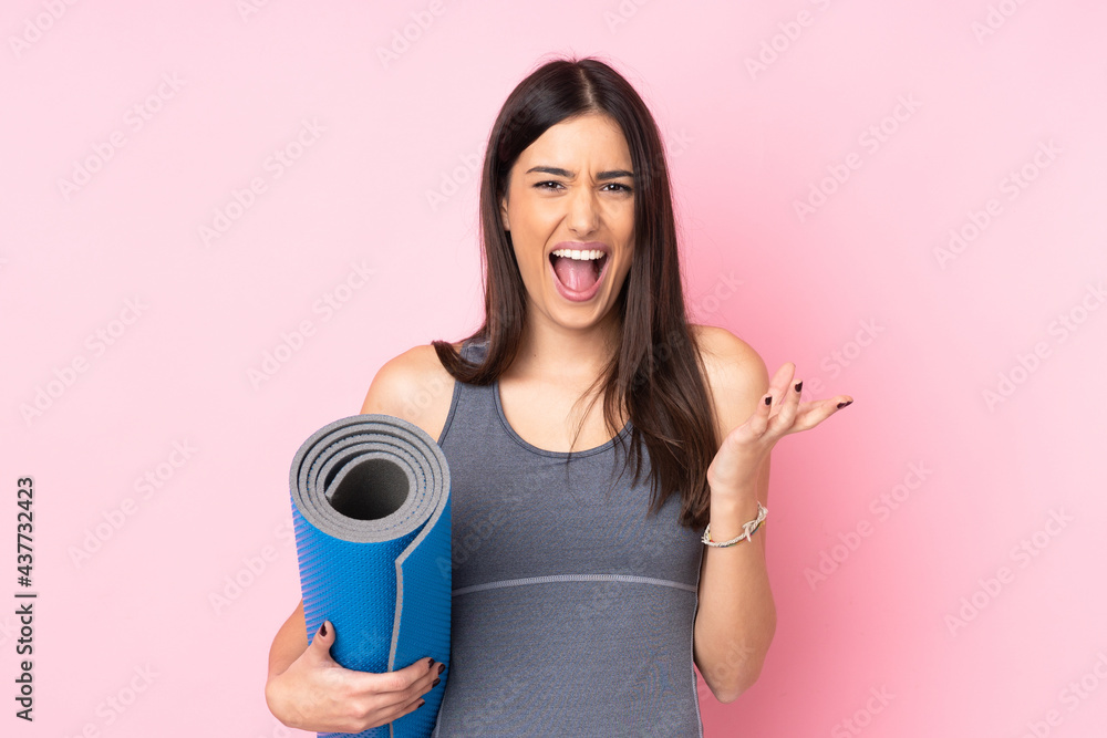 Young caucasian woman with mat isolated on pink background unhappy and frustrated with something Young caucasian woman with mat isolated on pink background unhappy and frustrated with something