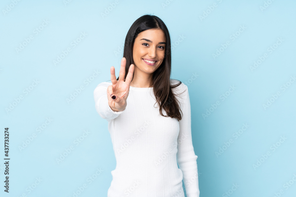 Young caucasian woman isolated on blue background happy and counting three with fingers Young caucasian woman isolated on blue background happy and counting three with fingers