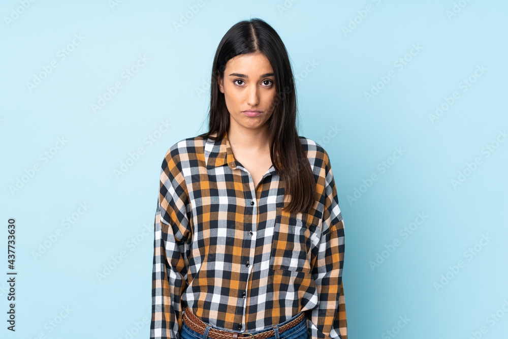 Young caucasian woman isolated on blue background with sad expression Young caucasian woman isolated on blue background with sad expression