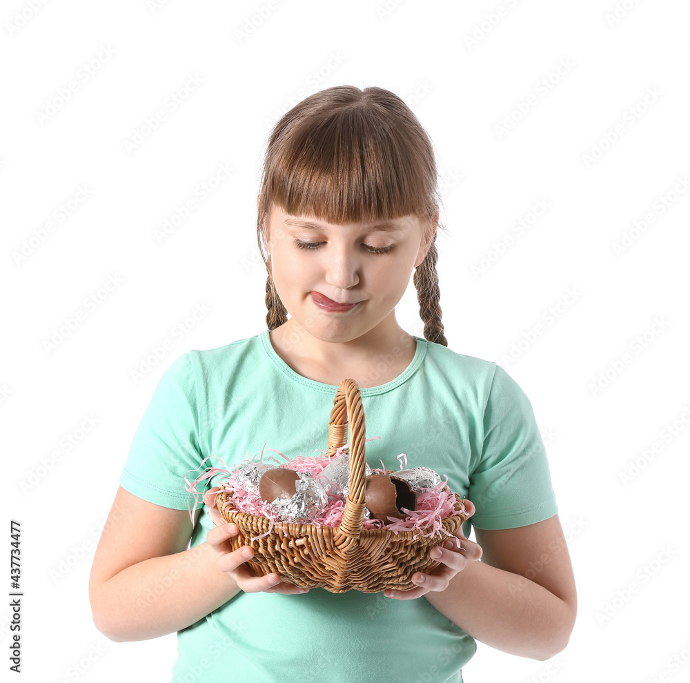 Cute little girl with basket of chocolate Easter eggs on white background