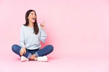Young caucasian woman isolated on pink background intending to realizes the solution while lifting a finger up