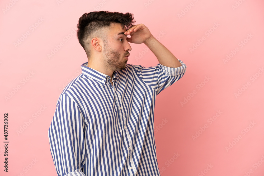Young caucasian man isolated on pink background with surprise expression while looking side Young caucasian man isolated on pink background with surprise expression while looking side