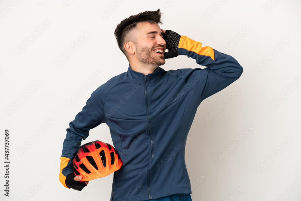 Young cyclist man isolated on white background smiling a lot - obrazy, fototapety, plakaty 