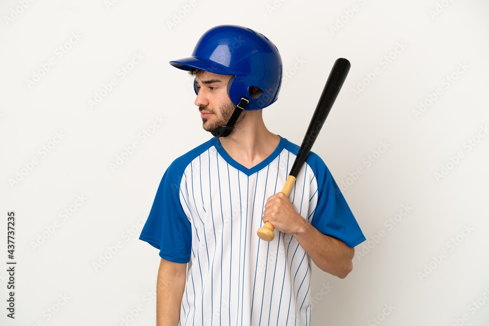 Young caucasian man playing baseball isolated on white background looking to the side