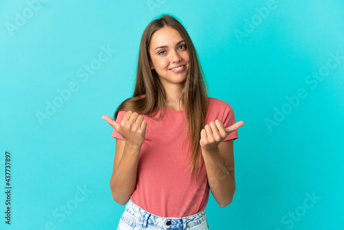 Young woman over isolated blue background with thumbs up gesture and smiling