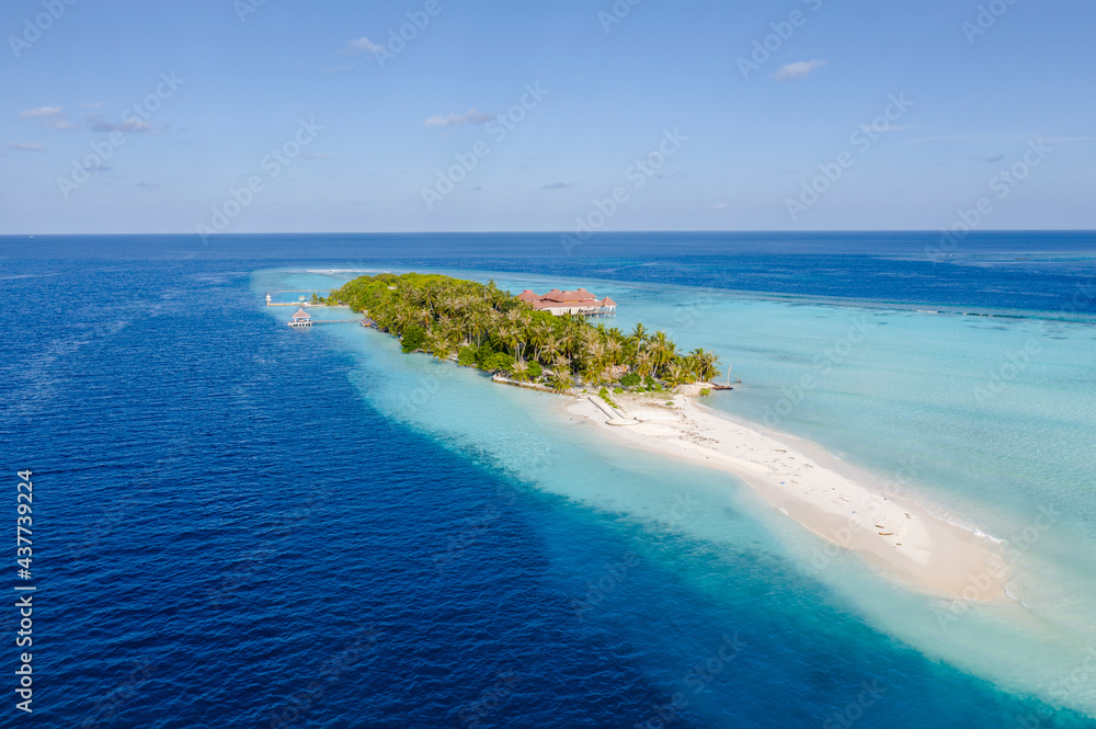 Aerial view of the Maldivian island with wooden houses on a   shallow water of a reef in the Indian Ocean