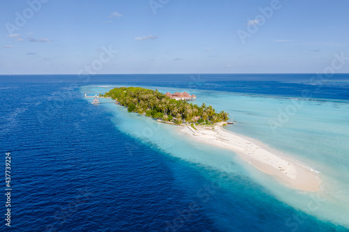 Aerial view of the Maldivian island with wooden houses on a shallow water of a reef in the Indian Ocean © Sergey