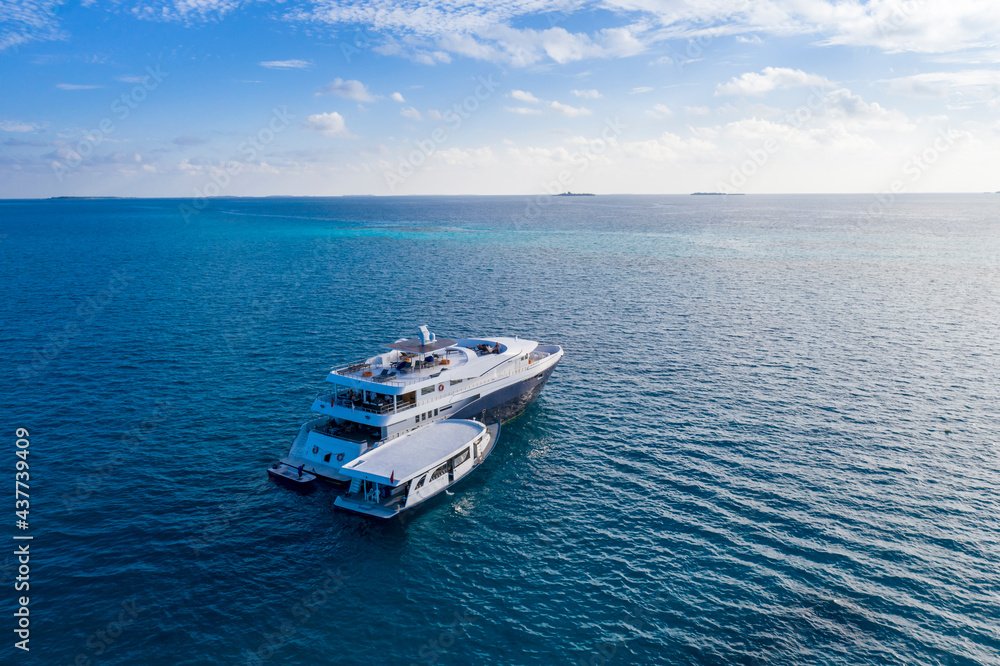 Aerial view of the motor boat approaching tourist ship in the Indian ocean with a small island on the horizon Aerial view of the motor boat approaching tourist ship in the Indian ocean with a small island on the horizon