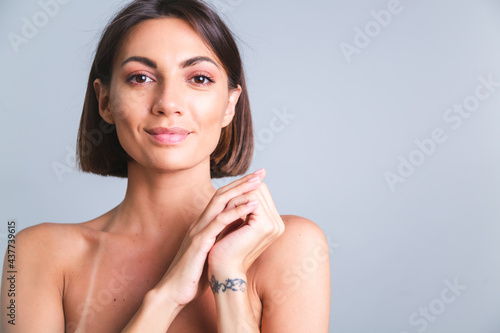 Natural beauty  portrait of topless woman with makeup and soft gentle  tanned skin on gray background