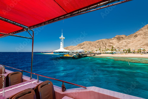 View from pleasure boat on underwater observatory building and beautiful coral reefs of the Red Sea, sandy beaches, tourist hotels and mountains, Red Sea, Sinai, Middle East