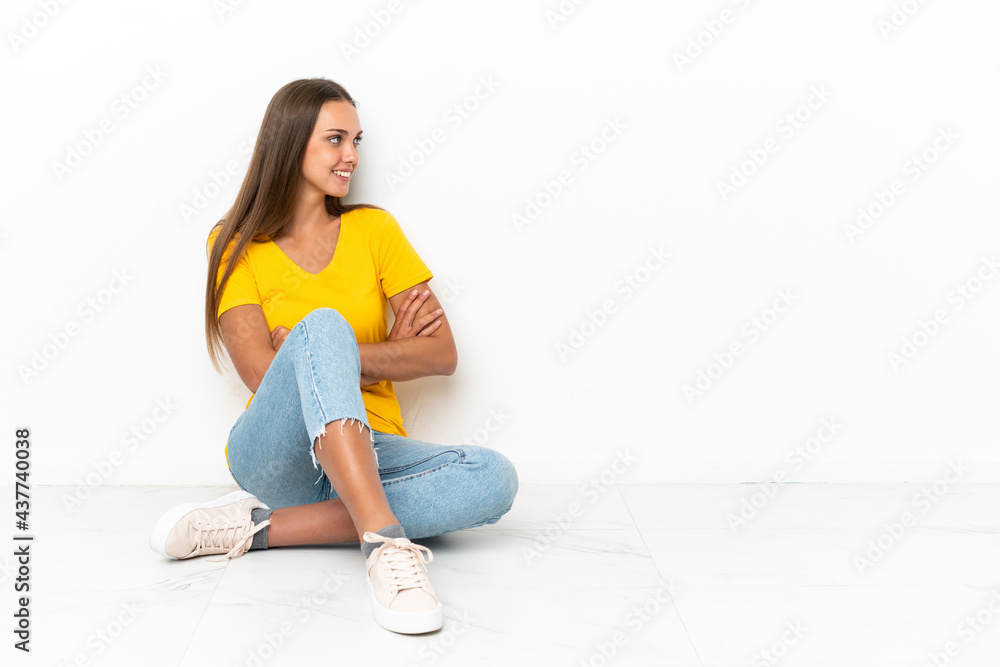 Young girl sitting on the floor in lateral position Young girl sitting on the floor in lateral position