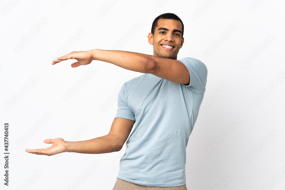 African American man over isolated white background holding copyspace to insert an ad African American man over isolated white background holding copyspace to insert an ad