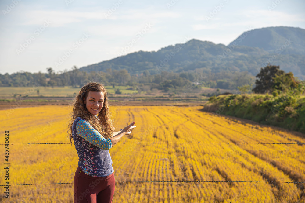 Woman showing a rice field.