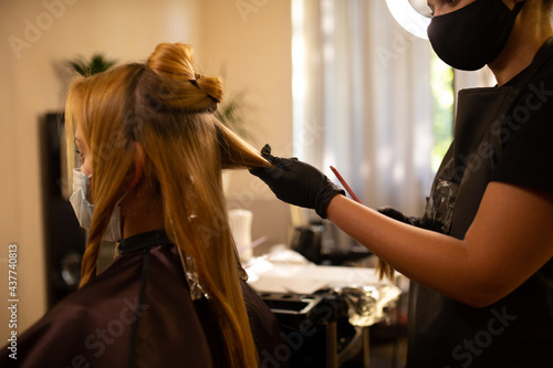 coloring hair, Hair dyeing. Young professional hairdresser applies hair dye to a female client. © Bogdan