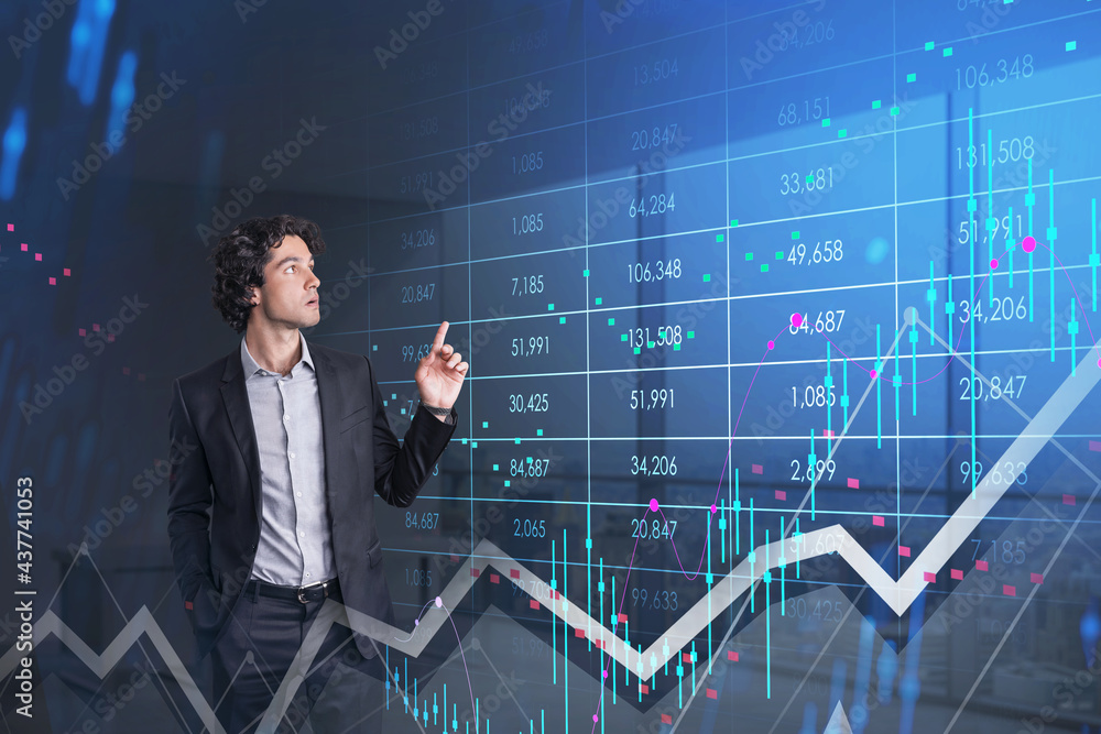 Focused young businessman looking at stock exchange graphs Focused young businessman looking at stock exchange graphs