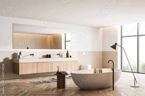 Bathtub and sink with mirror in wooden bathroom interior with window