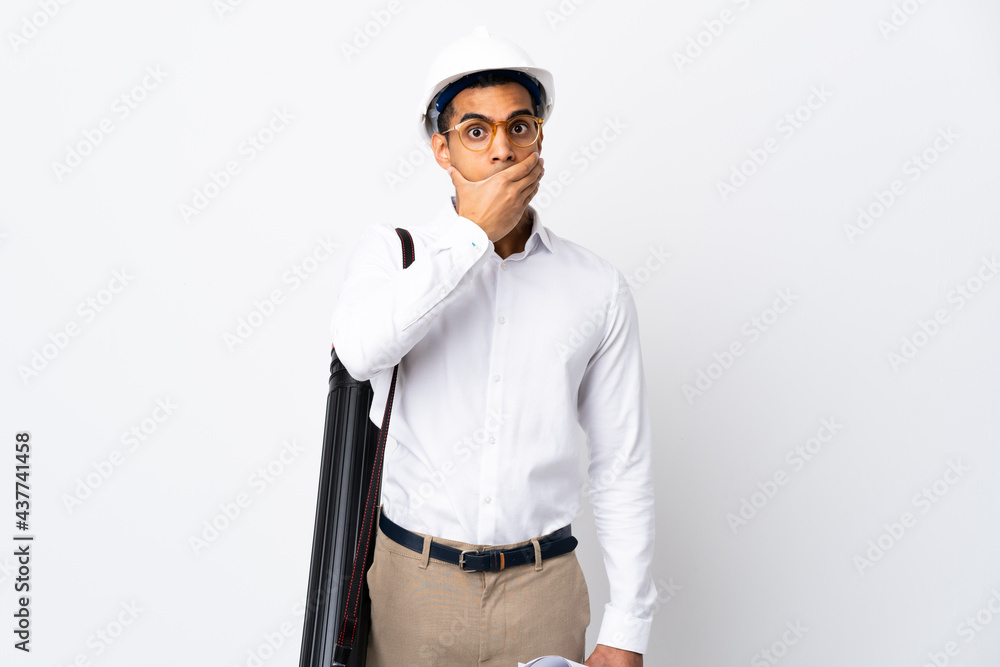 African American architect man with helmet and holding blueprints over isolated white background _ covering mouth with hand African American architect man with helmet and holding blueprints over isolated white background _ covering mouth with hand