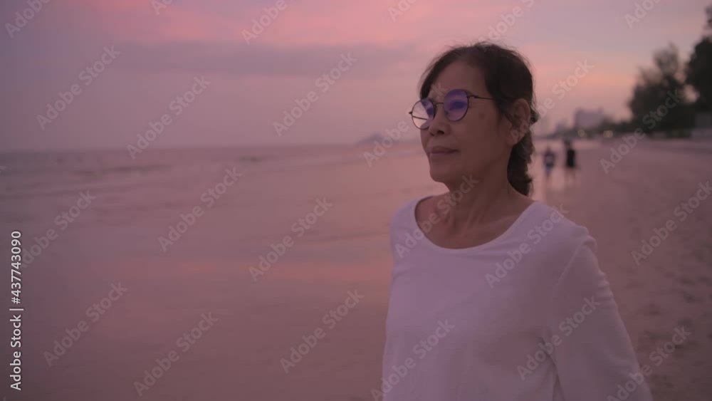 Travel concept of 4k Resolution. An asian old woman is breathing happily on the beach. Travel concept of 4k Resolution. An asian old woman is breathing happily on the beach.
