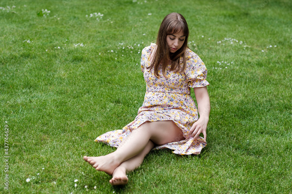 Relaxed young woman sitting on the grass in a spring day. Relaxed young woman sitting on the grass in a spring day.