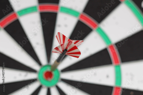 Conceptual photo. Darts on dart board outdoors in summer. Throw darts at the target. The winner, first place. Business target or goal success and winner concept.