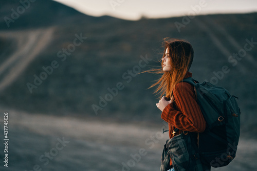 a woman in a theory family travels in nature in the mountains with a backpack on her shoulders