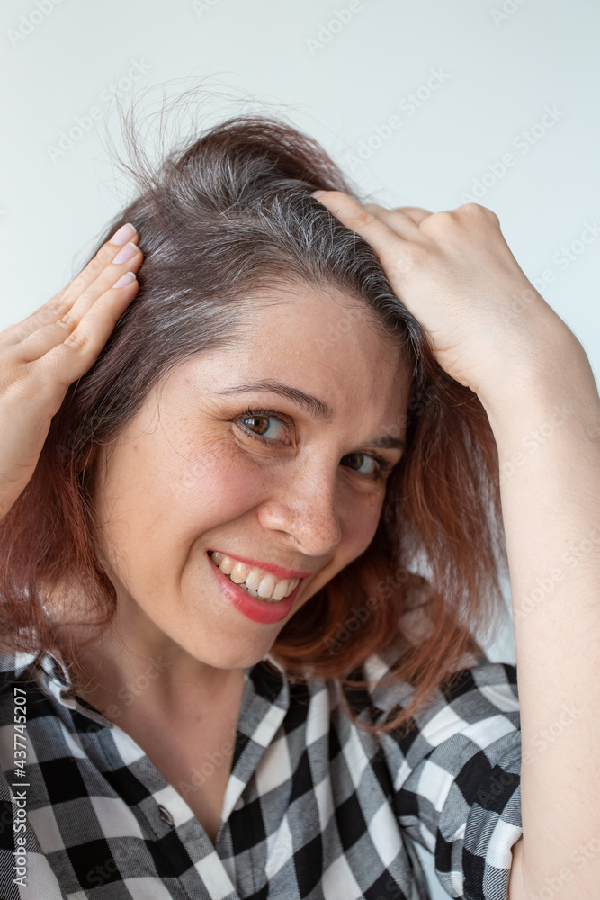Young woman shows her gray hair roots. Early aging concept. Young woman shows her gray hair roots. Early aging concept.