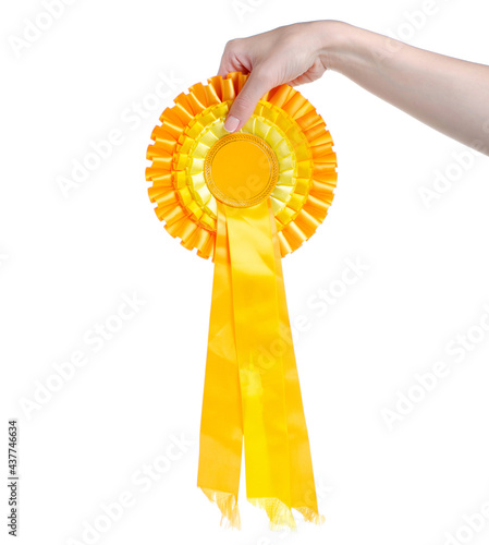 Yellow award ribbon in hand on white background isolation