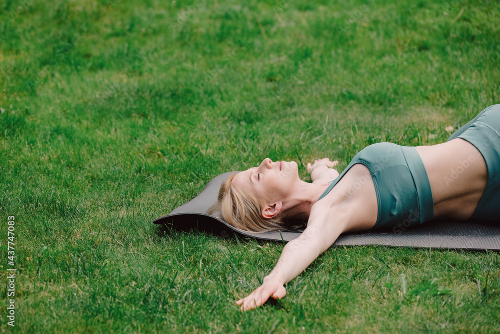 young woman practicing yoga on the grass in the garden young woman practicing yoga on the grass in the garden