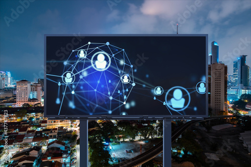 Glowing Social media icons on billboard over night panoramic city view of Kuala Lumpur, Malaysia, Asia. The concept of networking and establishing new connections between people and businesses in KL photo
