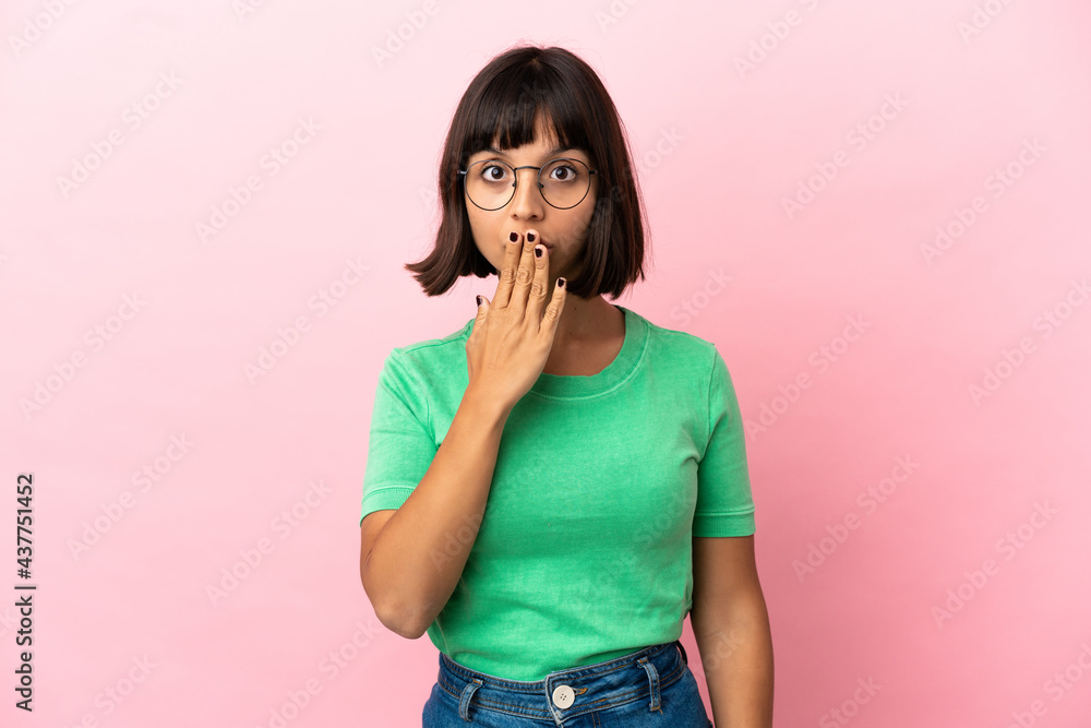 Young mixed race woman isolated on pink background covering mouth with hand Young mixed race woman isolated on pink background covering mouth with hand