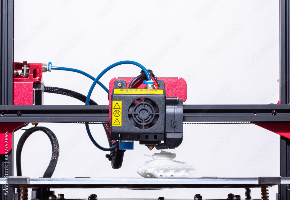 Working 3d printer. Printhead with hotend and fan close-up. Isolated on white background. Working 3d printer. Printhead with hotend and fan close-up. Isolated on white background.