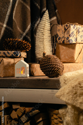 Christmas decor with fire logs, Australian bunya pine cone, warm blanket and gifts in a small forest house