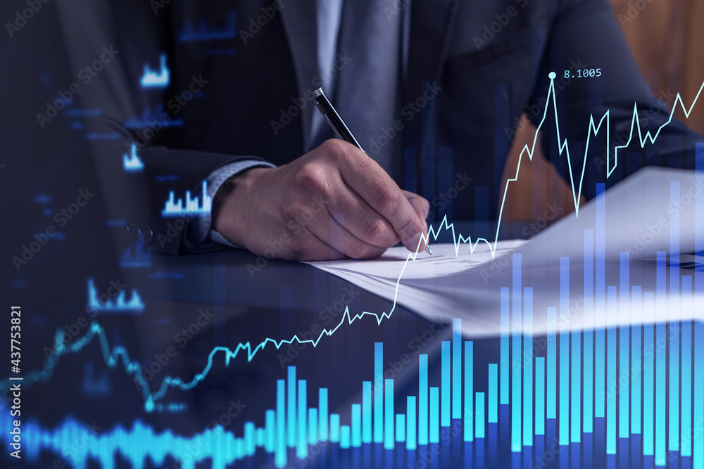 A client in formal wear is signing the contract to invest money in stock market. Internet trading and wealth management concept. Forex and financial hologram chart over the desk. A client in formal wear is signing the contract to invest money in stock market. Internet trading and wealth management concept. Forex and financial hologram chart over the desk.