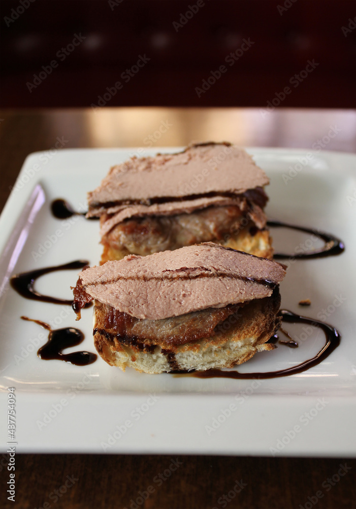 tostada de pan con solomillo de ternera, foie y sirope en plato blanco tostada de pan con solomillo de ternera, foie y sirope en plato blanco