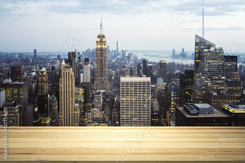 Empty wooden tabletop with beautiful New York skyscrapers at night on background  mock up