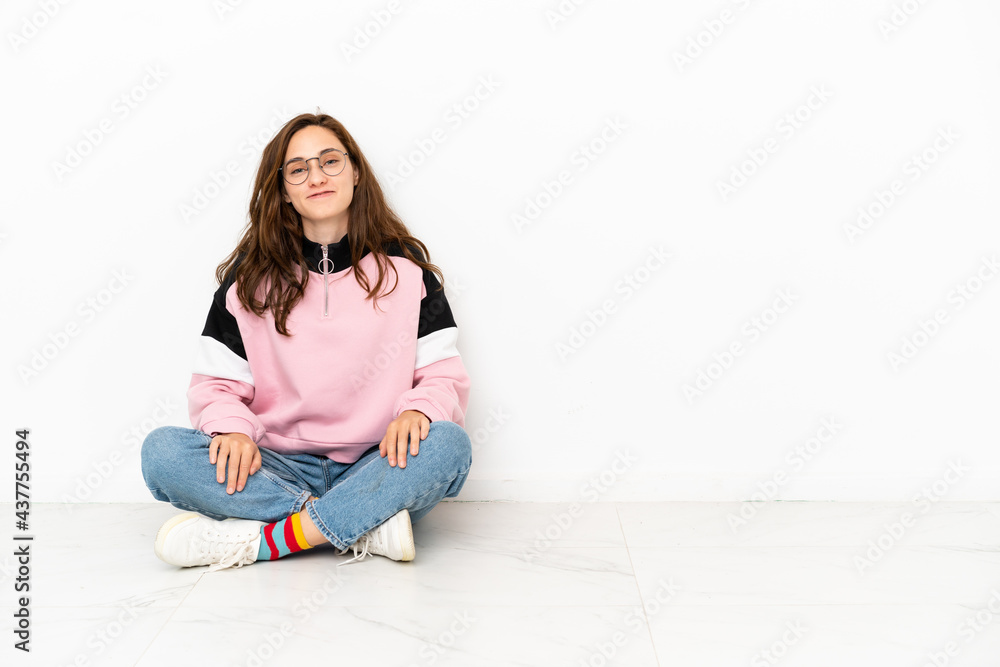 Young caucasian woman sitting on the floor isolated on white background laughing Young caucasian woman sitting on the floor isolated on white background laughing