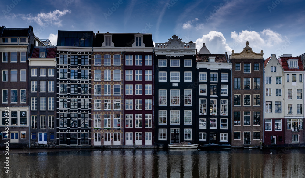 view of the iconic houses on the waterfront at the Damrak in downtown Amsterdam