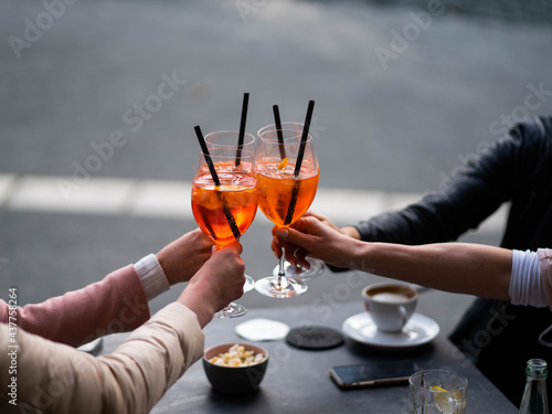 four girls, clinking glasses, celebrate in the afternoon on the terrace