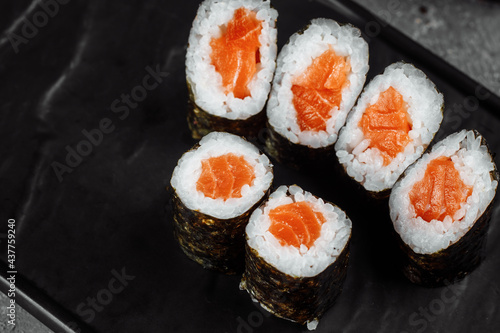 Simple maki with fresh salmon. Sushi on a gray background