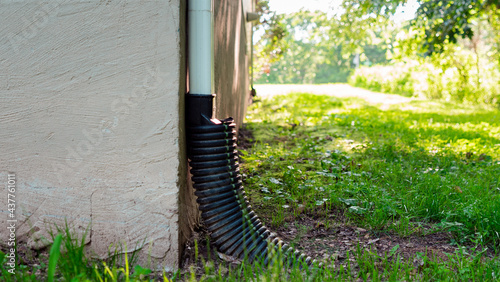 Фотография Rain gutter drainpipe into the ground to prevent flooding