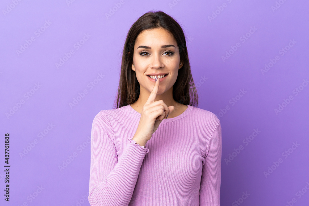 Young caucasian woman over isolated background showing a sign of silence gesture putting finger in mouth Young caucasian woman over isolated background showing a sign of silence gesture putting finger in mouth