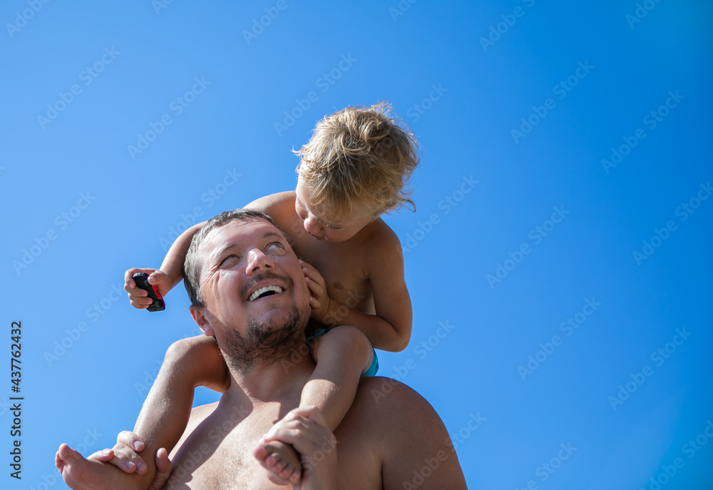 Portrait of a father with his little son on his shoulders. Portrait of a father with his little son on his shoulders.