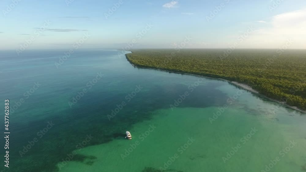 Crystal sea waters surrounded by lush vegetation, Palmilla in Dominican Republic. Aerial backward Crystal sea waters surrounded by lush vegetation, Palmilla in Dominican Republic. Aerial backward