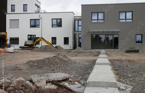Baustelle von modernen Häusern mit Bagger