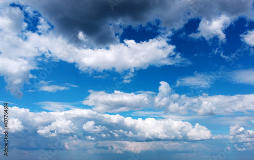 Beautiful contrasting large clouds in blue sky for background © Payllik