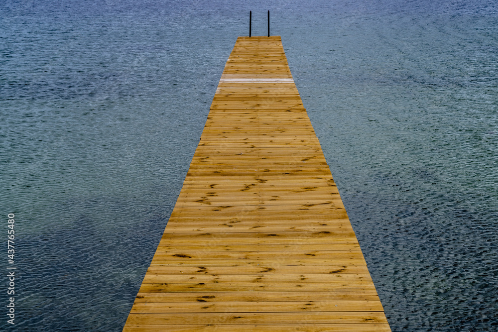 view of a long wooden pier leading out into clear ocean waters view of a long wooden pier leading out into clear ocean waters