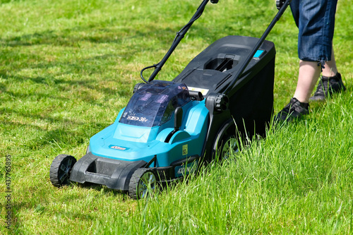 Mowing the grass with a lawn mower. Maintenance garden