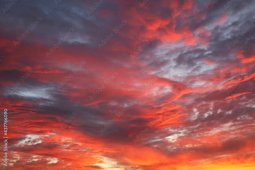 Sunset on colorful dramatic sky with red clouds. Picturesque landscape for background with inferno atmosphere