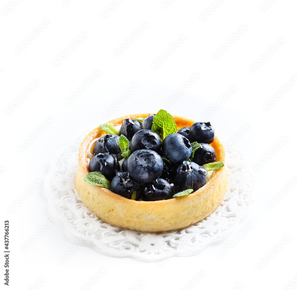 Blueberry tart with fresh mint leaves at white background, top view. French dessert with berries. Blueberry tart with fresh mint leaves at white background, top view. French dessert with berries.